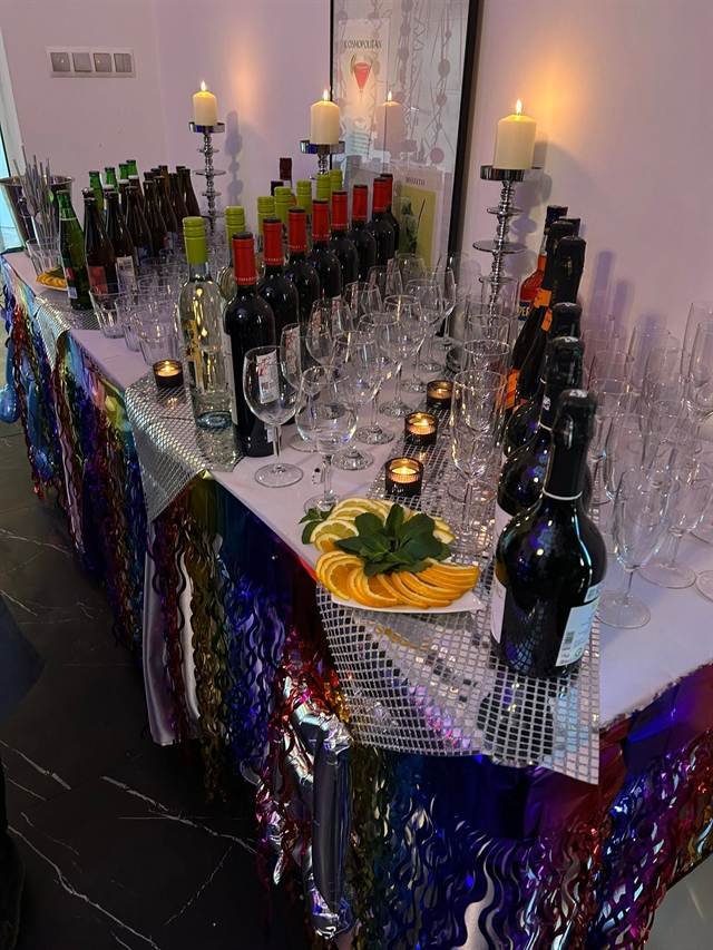 Bar z winem, piwem i kieliszkami przy świecach, z plastrami pomarańczy i miętą