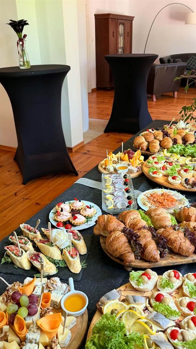 Catering na spotkaniu z wysokimi stolikami koktajlowymi i przekąskami