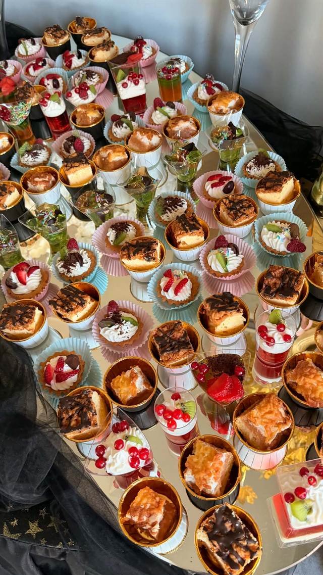 Mini desery i babeczki z kremem i owocami na lustrzanej tacy