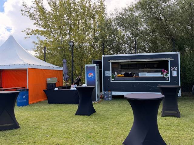 Impreza w plenerze: food truck, wysokie stoliki na trawie i namiot