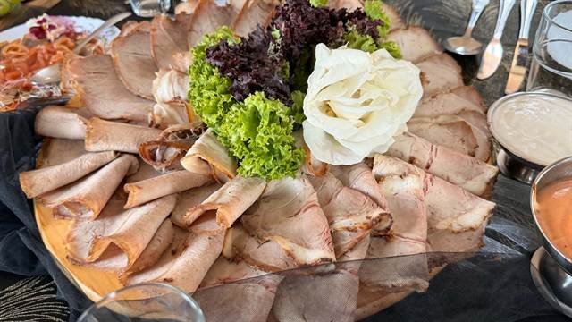 Pieczone mięsa w plastrach na drewnianym półmisku z sosami