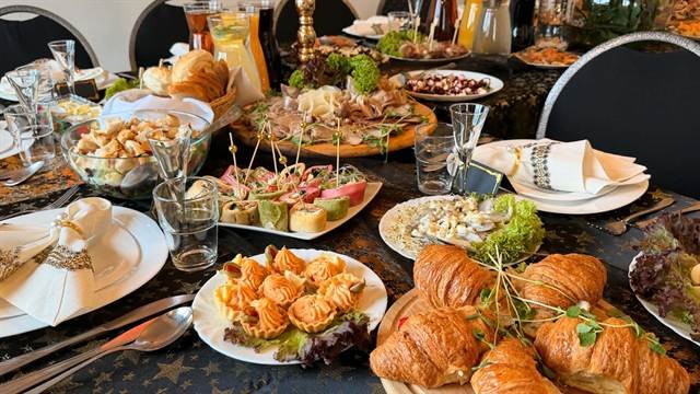 Stół z przystawkami: croissanty, tartaletki, roladki, półmisek mięs i pieczywo
