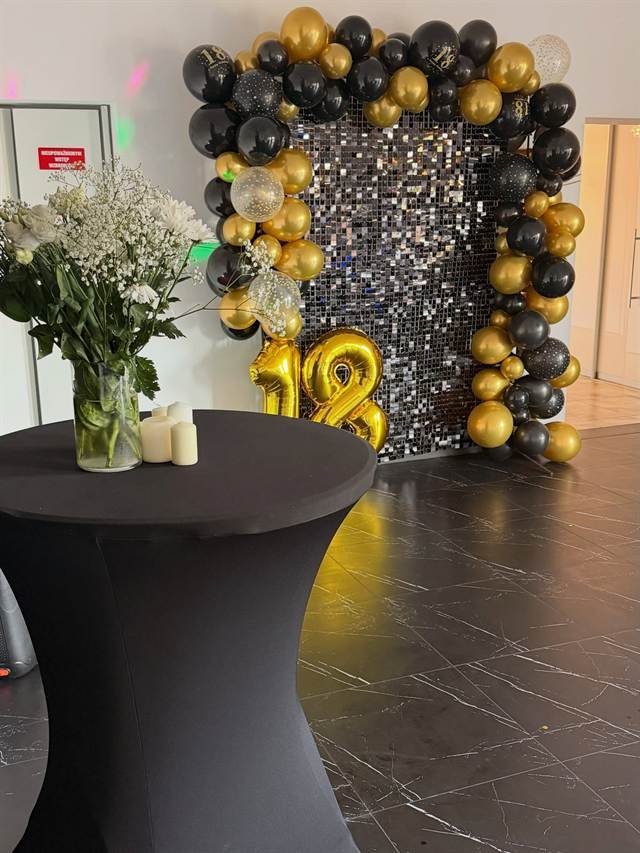 Dekoracja z czarnych i złotych balonów z cyfrą 18